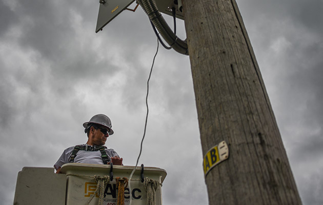 Lineman in a bucket truck next to a power pole